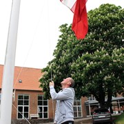 Flemming Thomsen hejser flaget i skolegården på Munkevej.jpg